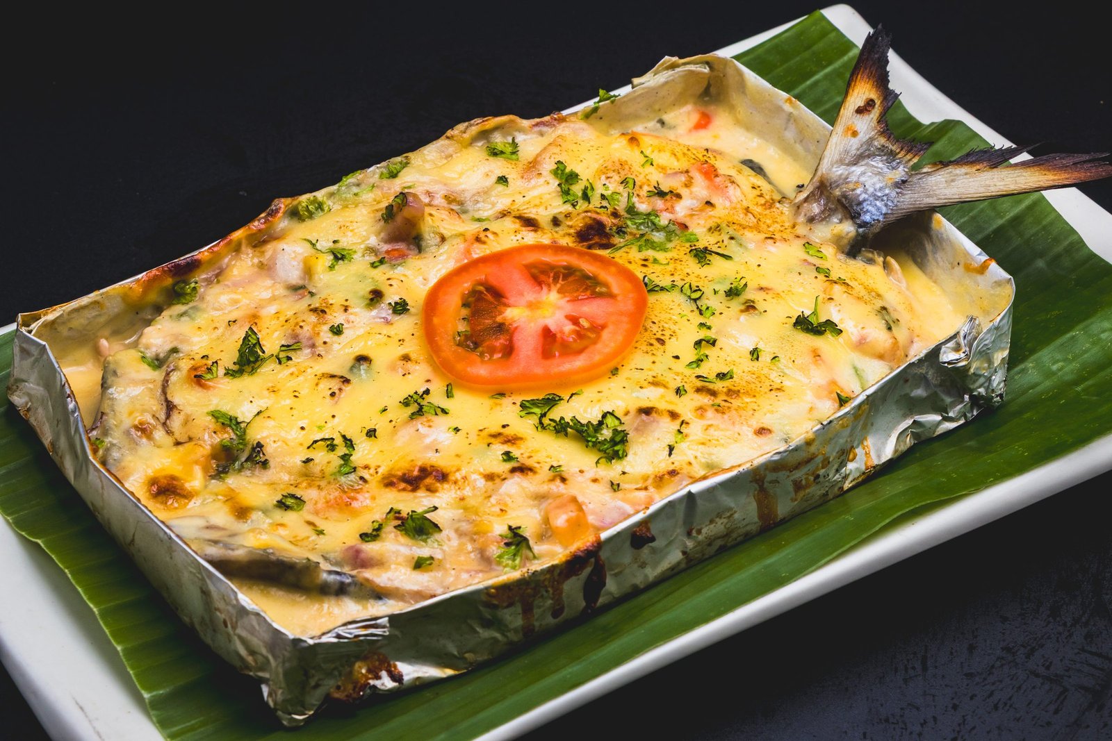 Cheesy grilled bangus baked in foil on a banana leaf