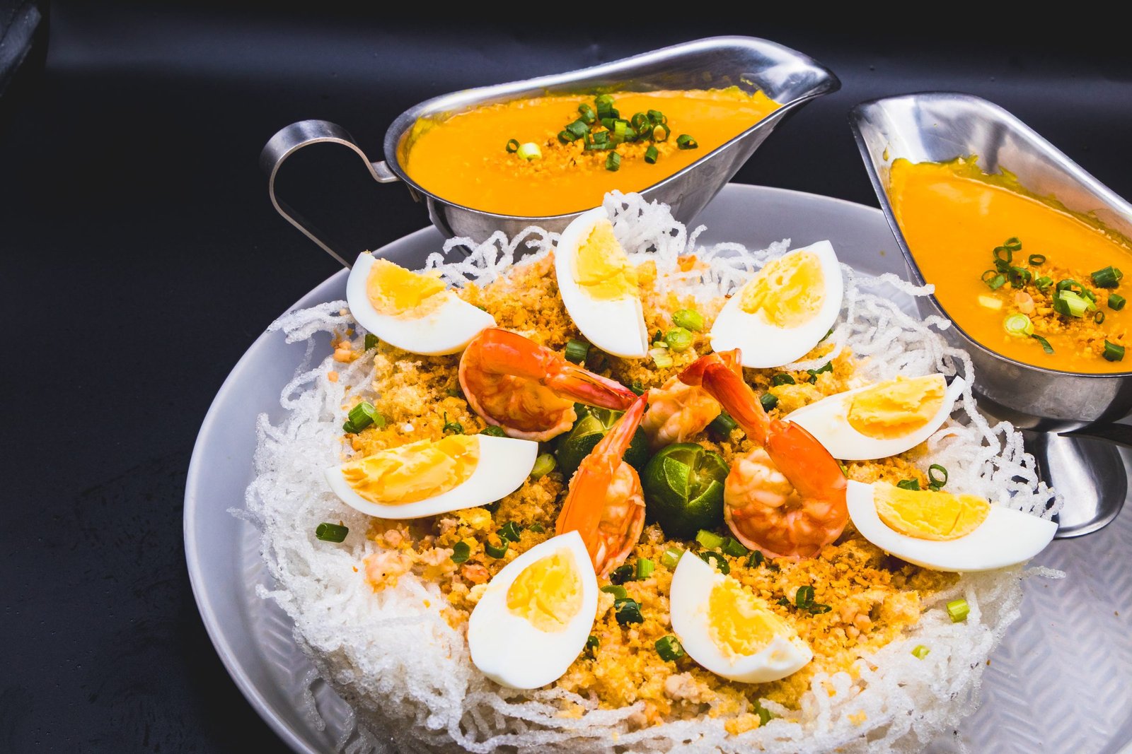 Crispy palabok topped with shrimp, egg and chicharon, sauce on the side