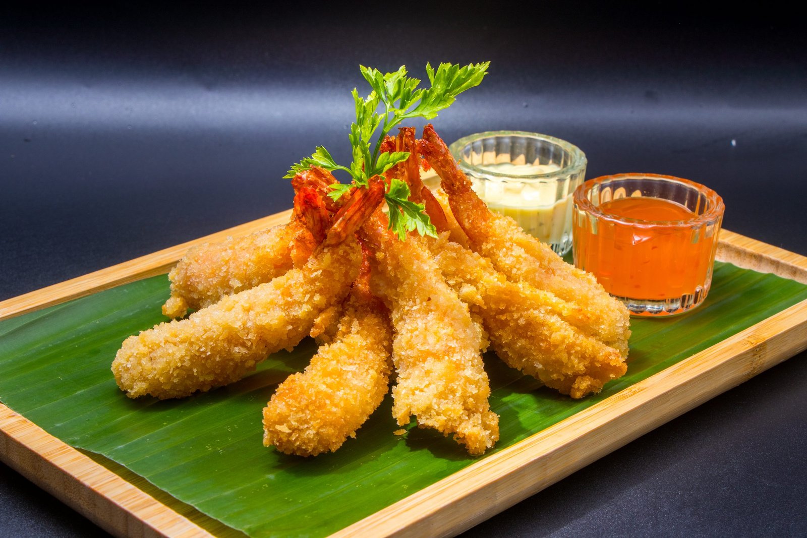 Shrimp tempura on a banana leaf with two dipping sauces